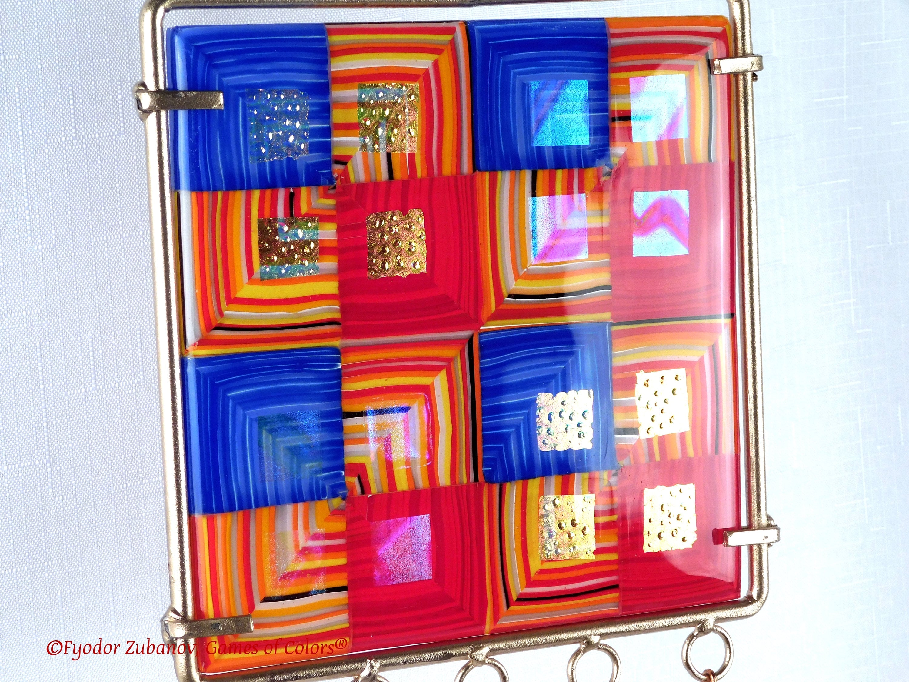 Wind chime with the main glass body surrounded by black frame and glass strips hanging on short chains