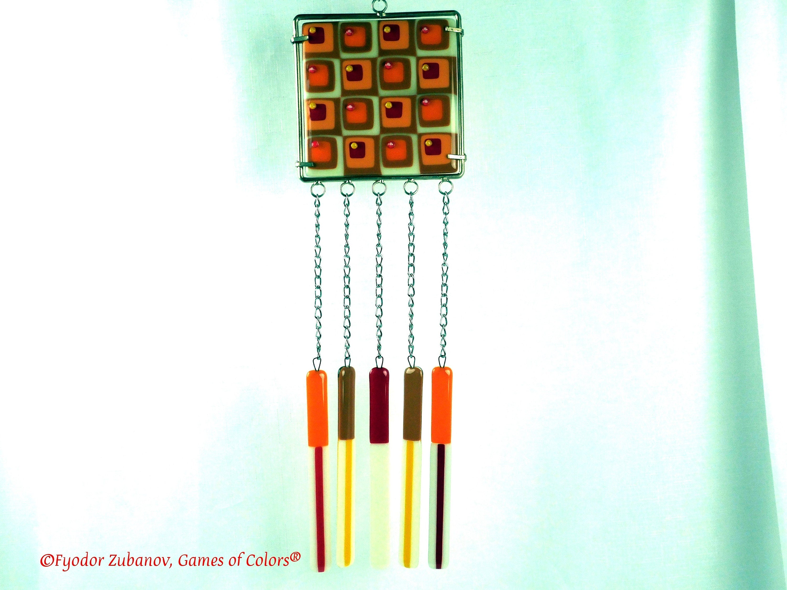Wind chime with the main glass body surrounded by black frame and glass strips hanging on short chains