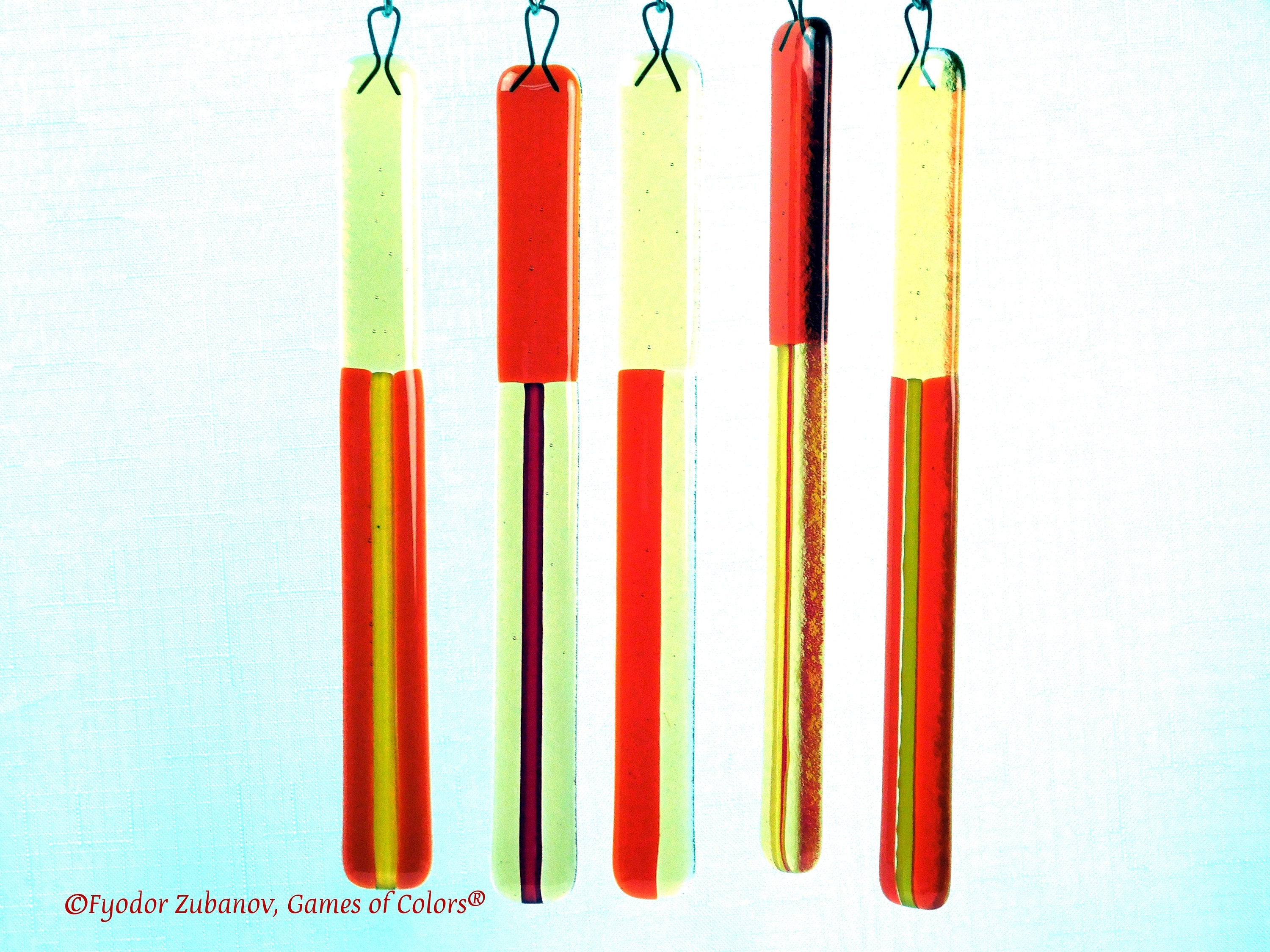 Wind chime with the main glass body surrounded by black frame and glass strips hanging on short chains