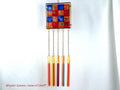 Wind chime with the main glass body surrounded by black frame and glass strips hanging on short chains