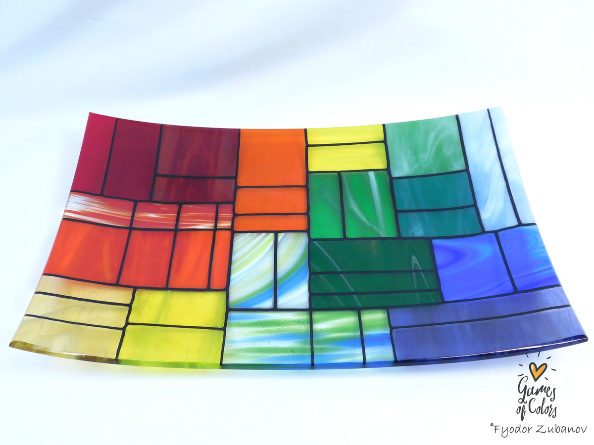 A colorful stained-glass-style rectangular plate or tray with a mosaic of multiple colors glass sections separated by dark grout lines, photographed on a white background. The plate is from the Gentle Color Mix collection. Branded as Fyodor Zubanov, Games of Colors