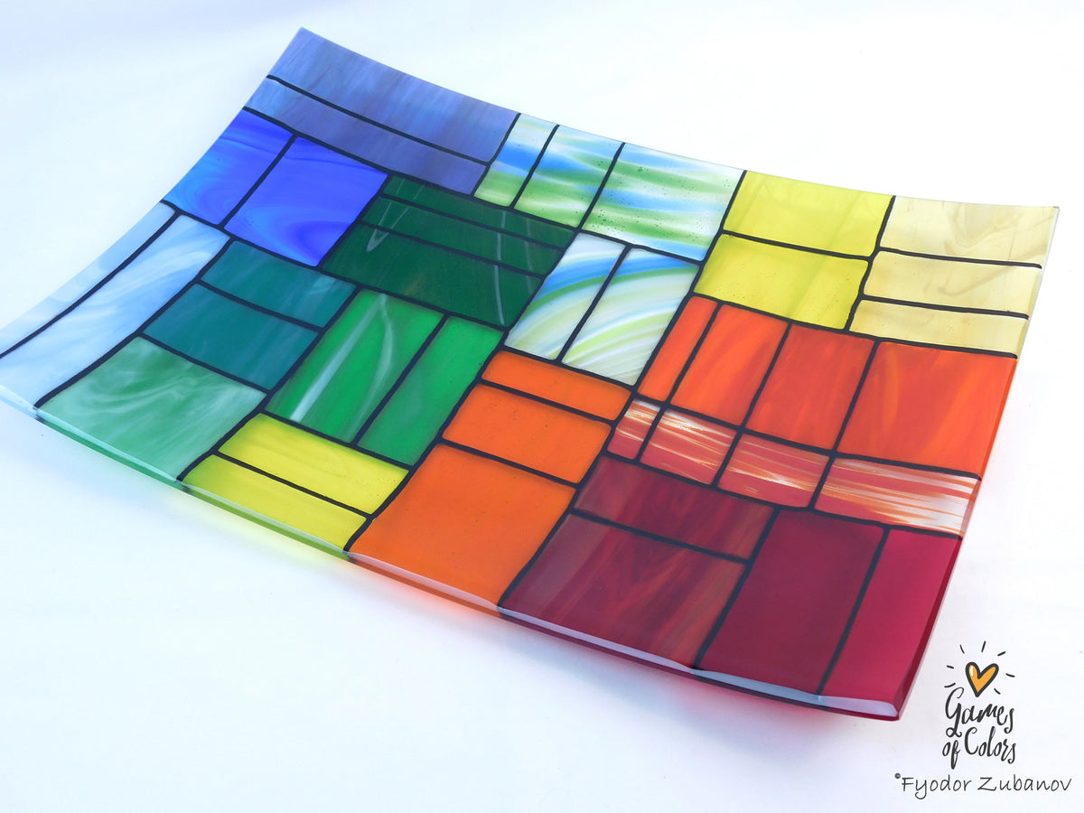 A colorful stained-glass-style rectangular plate or tray with a mosaic of multiple colors glass sections separated by dark grout lines, photographed on a white background. The plate is from the Gentle Color Mix collection. Branded as Fyodor Zubanov, Games of Colors