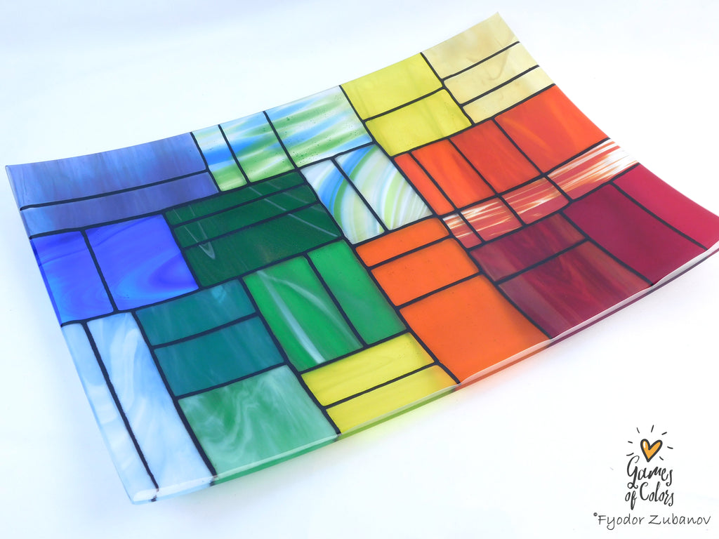 A colorful stained-glass-style rectangular plate or tray with a mosaic of multiple colors glass sections separated by dark grout lines, photographed on a white background. The plate is from the Gentle Color Mix collection. Branded as Fyodor Zubanov, Games of Colors