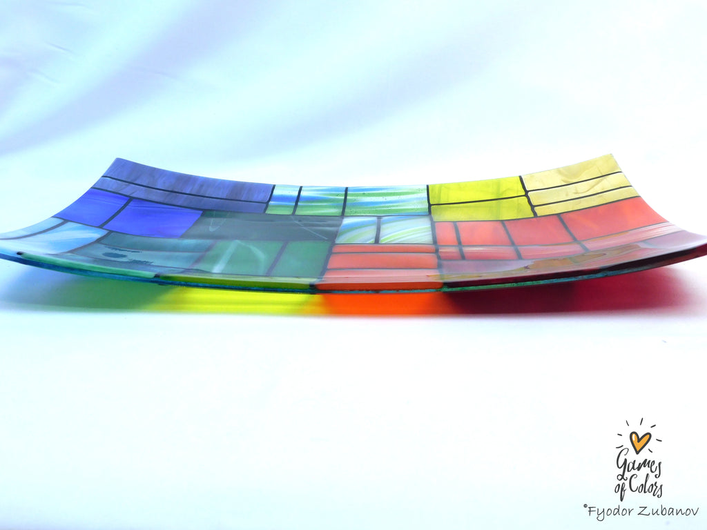 A colorful stained-glass-style rectangular plate or tray with a mosaic of multiple colors glass sections separated by dark grout lines, photographed on a white background. The plate is from the Gentle Color Mix collection. Branded as Fyodor Zubanov, Games of Colors