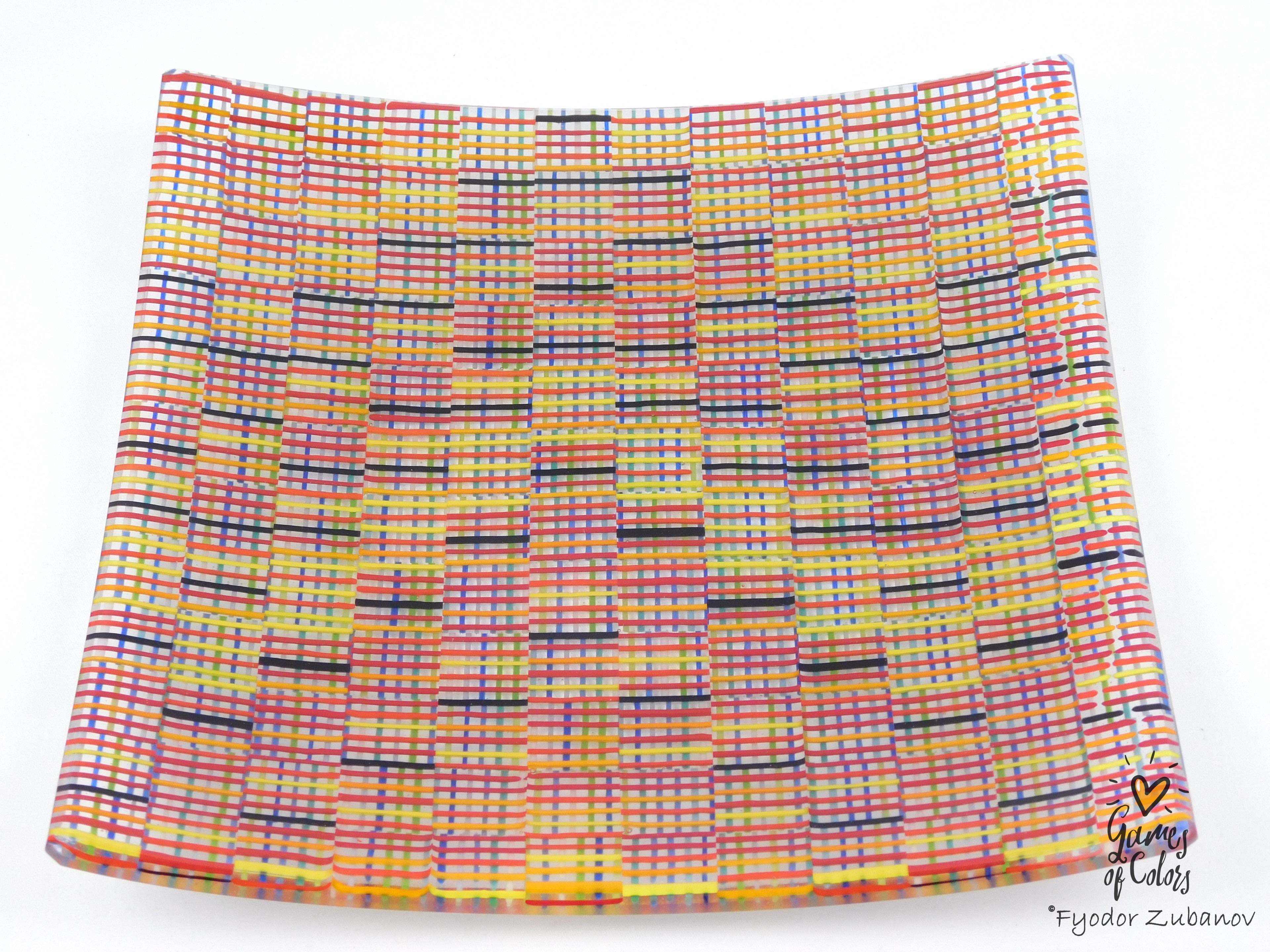 A square glass plate imitating fabric with a vibrant, multicolored geometric pattern featuring diagonal stripes and mesh-like textures in yellow, blue, green. and a watermark in the bottom right corner reads 'Fyodor Zubanov' and 'Games of Colors'.