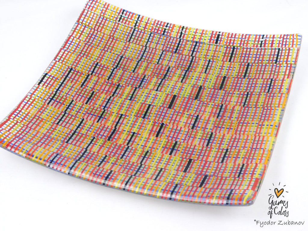 A square glass plate imitating fabric with a vibrant, multicolored geometric pattern featuring diagonal stripes and mesh-like textures in yellow, blue, green. and a watermark in the bottom right corner reads 'Fyodor Zubanov' and 'Games of Colors'.