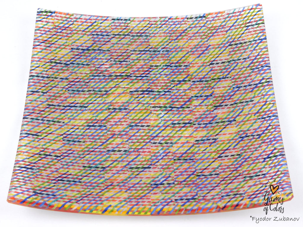 A square glass plate imitating fabric with a vibrant, multicolored geometric pattern featuring diagonal stripes and mesh-like textures in yellow, blue, green. and a watermark in the bottom right corner reads 'Fyodor Zubanov' and 'Games of Colors'.