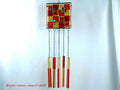 Wind chime with the main glass body surrounded by black frame and glass strips hanging on short chains