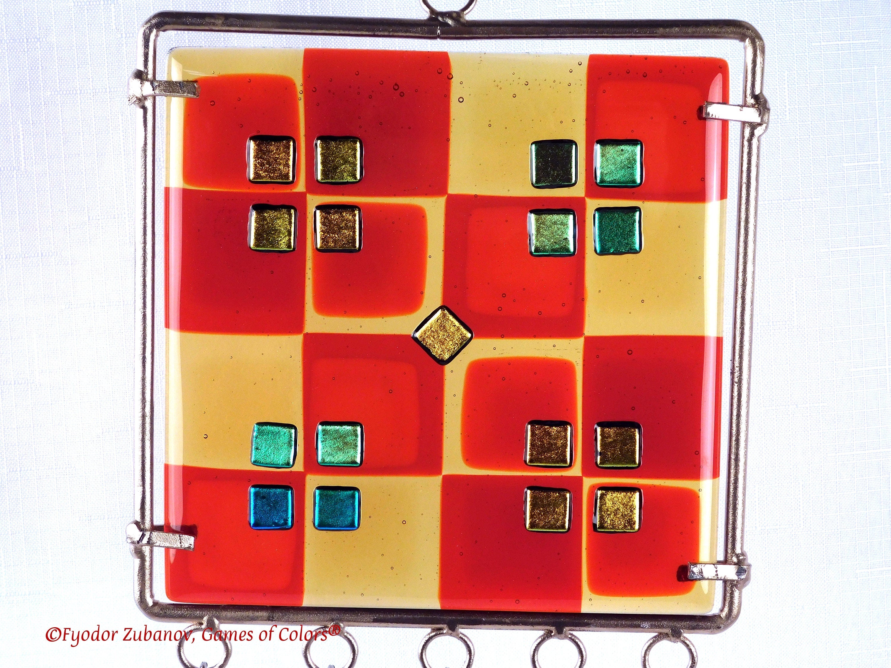 Wind chime with the main glass body surrounded by black frame and glass strips hanging on short chains