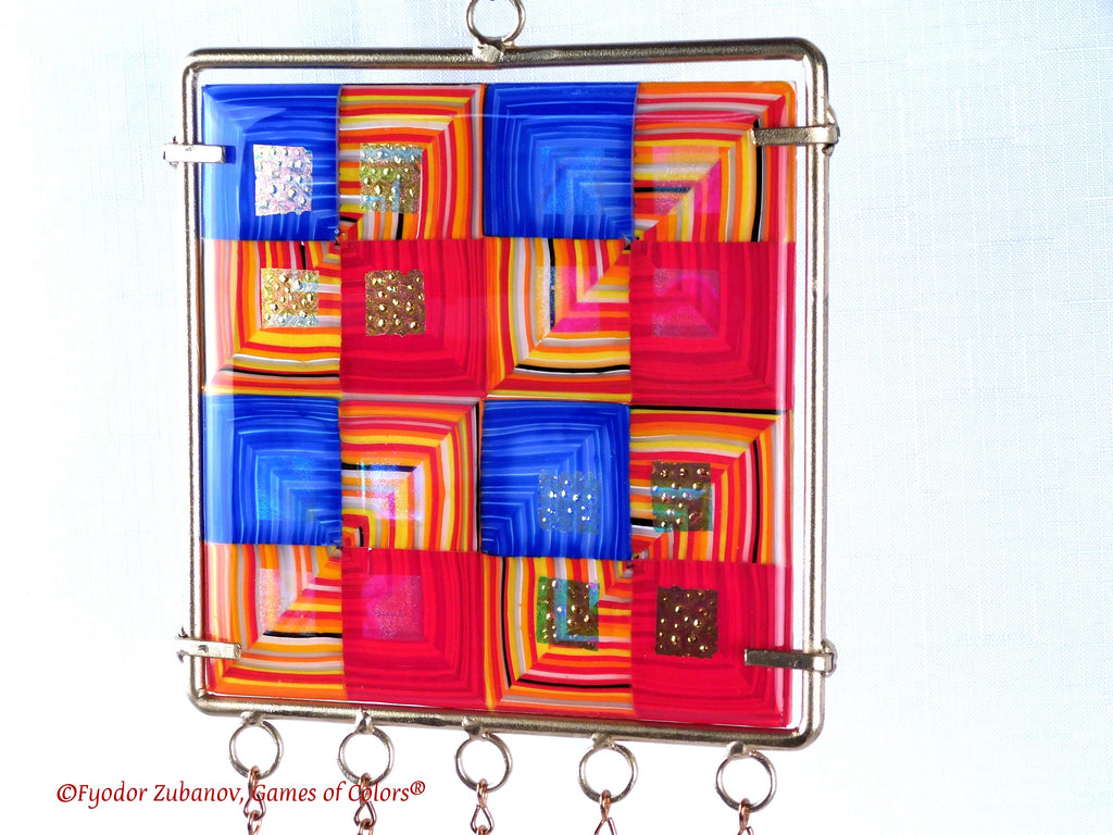 Wind chime with the main glass body surrounded by black frame and glass strips hanging on short chains