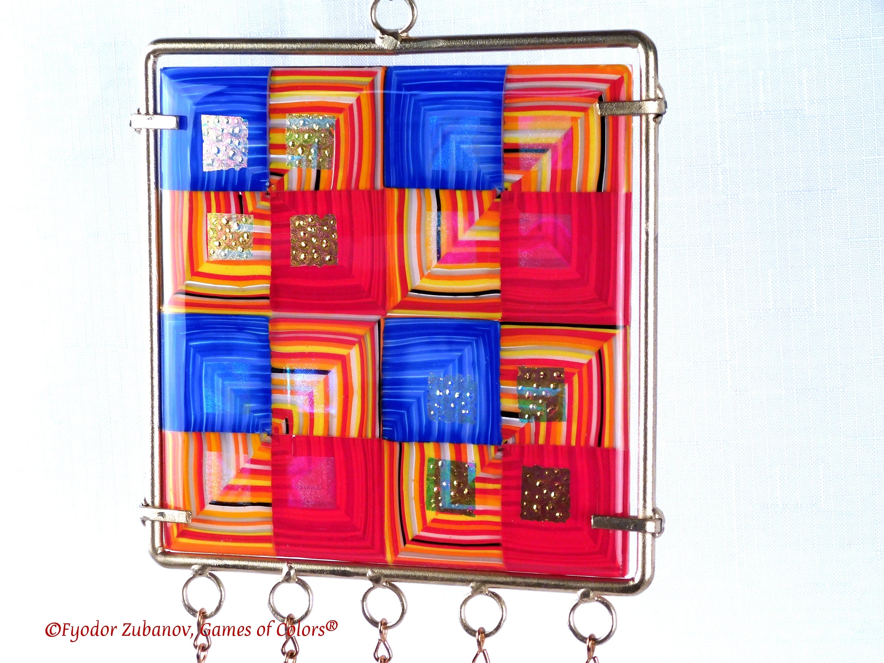 Wind chime with the main glass body surrounded by black frame and glass strips hanging on short chains